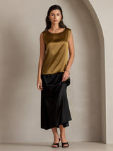 Women's silk sleeveless round neck tank top in gold, styled with black skirt