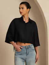 Black silk cropped blouse with lapel collar, half sleeves, and drawstring hem styled with jeans