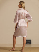 Woman wearing pink heart geo printed silk knee-length kimono robe with tie belt