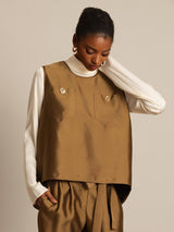 Model wearing brown silk-wool blend vest with button pockets over a white top