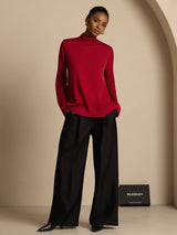 Woman wearing red silk turtleneck long sleeve top with black wide-leg pants