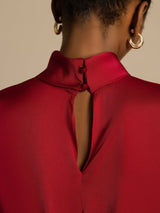 Red silk turtleneck top with keyhole back and ball button closure