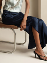 Model wearing navy silk wide leg pants with side slit and elastic waist