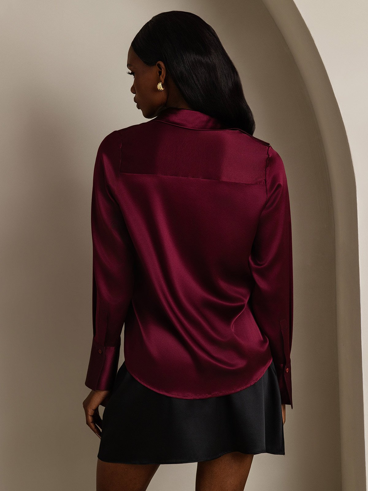 Women’s burgundy silk long sleeve lapel shirt with curved hem, back view