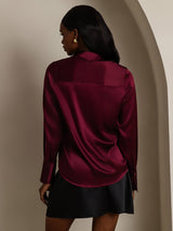 Women’s burgundy silk long sleeve lapel shirt with curved hem, back view
