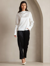 White silk long sleeve boat neck blouse with draped neckline and pearl button details