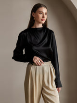 Black silk long sleeve boat neck blouse with draped front and beige trousers
